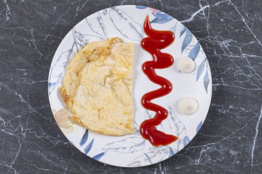 Omlet mayonezin yanında ve ketçap tabakta, mermer zeminde. Yüksek kalite fotoğraf