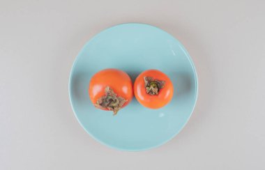 Doğu hurması mermer arka planda mavi bir tabakta. Yüksek kalite fotoğraf