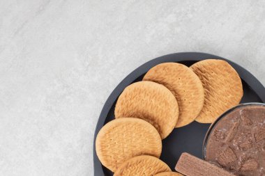 Koyu tahtada bir bardak kahve ve çeşitli bisküviler. Yüksek kalite fotoğraf