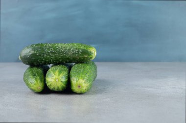 Gri arka planda dört taze salatalık izole edilmiş. Yüksek kalite fotoğraf