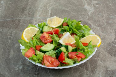 Beyaz tabakta limon dilimleri olan sebze salatası. Yüksek kalite fotoğraf