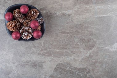 Çam kozalakları ve noel mücevherleri mermer arka planda bir kasede. Yüksek kalite fotoğraf