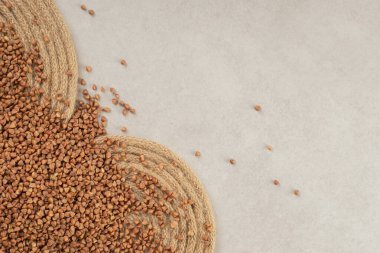 Çiğ karabuğday taneleri mermer zemine saçılmış vaziyettedir. Yüksek kalite fotoğraf