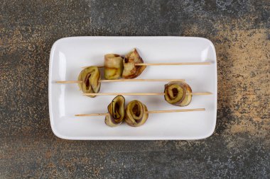 Beyaz kare tabakta çubuk içinde lezzetli patlıcanlar. Yüksek kalite fotoğraf