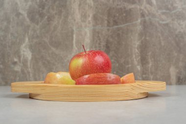 Ahşap tabakta tam ve kırmızı elma dilimleri. Yüksek kalite fotoğraf