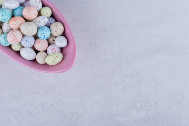 Beton arka planda bir tabakta çok renkli şeker topları. Yüksek kalite fotoğraf
