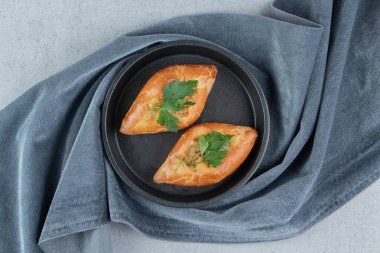 Mermer arka plandaki masa örtüsüne yerleştirilmiş bir kasede küçük pide tabakları. Yüksek kalite fotoğraf