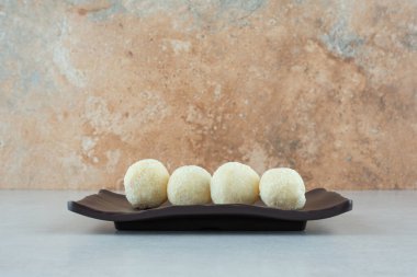 İçinde yuvarlak lezzetli kurabiyeler olan siyah bir tabak. Yüksek kalite fotoğraf