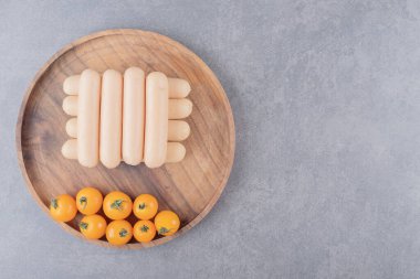 Haşlanmış sosis ve kiraz sarısı domatesli ahşap bir tabak. Yüksek kalite fotoğraf