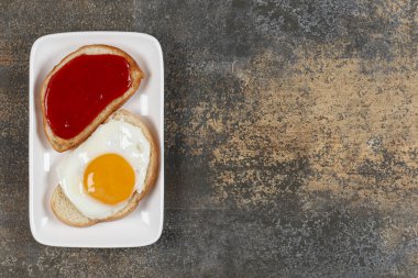 Kızarmış yumurtalı tost ve beyaz tabakta reçel. Yüksek kalite fotoğraf