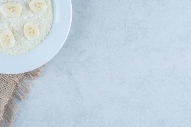 Pirinç tabağında dilimlenmiş muz, mermer zemin üzerinde. Yüksek kalite fotoğraf