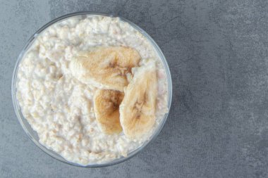 Bir tabak yulaf lapası, yanında da muz dilimleri. Yüksek kalite fotoğraf