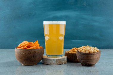 Bir bardak bira ve ahşap kase lezzetli atıştırmalıklar. Yüksek kalite fotoğraf