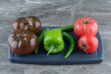 Tepside domates ve biber var, mermer arka planda. Yüksek kalite fotoğraf