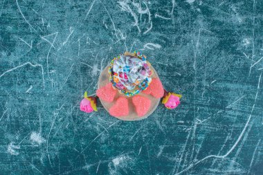 Kek, marmelat ve çiçek korollaları mavi arka planda bir araya toplanmış. Yüksek kalite fotoğraf