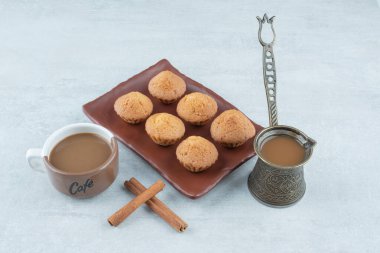 Tarçın çubuklu Aroma kahvesi ve beyaz arka planda kekler. Yüksek kalite fotoğraf