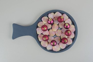 Kalp şeklinde jöle şekerlemelerle dolu tahta bir tabak ve Noel topları. Yüksek kalite fotoğraf