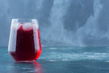 Mavi arka planda işlenmiş bir bardak meyve suyu. Yüksek kalite fotoğraf