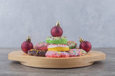 İstiflenmiş çörekler ve noel mücevherleri mermer arka planda ahşap bir tabakta. Yüksek kalite fotoğraf