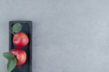 Mermer zemin üzerinde siyah bir tepside taze elmalar. Yüksek kalite fotoğraf