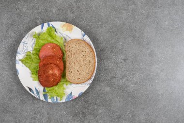 Renkli tabakta çavdar ekmeği dilimi ve sosis. Yüksek kalite fotoğraf