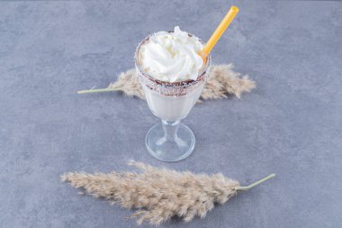 Gri arka planda kremalı milkshake 'in yakın plan fotoğrafı. Yüksek kalite fotoğraf