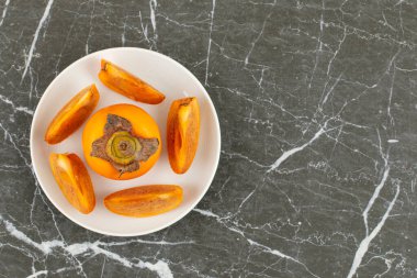 Beyaz tabakta dilimlenmiş hurmanın üst görüntüsü. Yüksek kalite fotoğraf