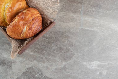 Sırt grubunda mermer üzerinde çeşitli lezzetli hamur işleri bulunan ahşap kutu. Yüksek kalite fotoğraf