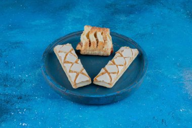 Mavi tabakta üç kurabiye, mavi arka planda. Yüksek kalite fotoğraf