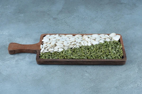 白色清洁的绿色南瓜种子放在木制盘子里 高质量的照片 — 图库照片