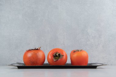 Metal tepside olgun hurma meyveleri. Yüksek kalite fotoğraf