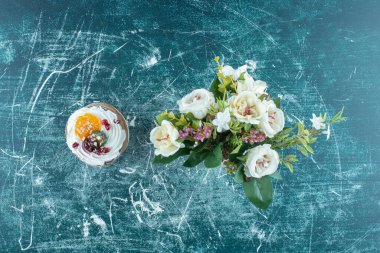 Mavi arka planda bir kek ve bir demet çiçek. Yüksek kalite fotoğraf
