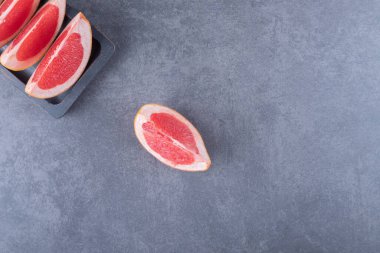 Gri arka planda taze greyfurt dilimlerinin üst görüntüsü. Yüksek kalite fotoğraf