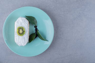 Tabağında kivi dilimi olan taze kremalı pasta. Yüksek kalite fotoğraf