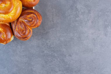 Çörekler mermer arka planda küçük bir sepetin üzerine yığılmış. Yüksek kalite fotoğraf