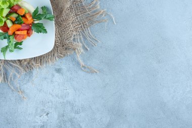 Havuç, biber, salatalık, marul dilimleri ve mermer arka planda salata tabağında maydanoz yaprakları. Yüksek kalite fotoğraf