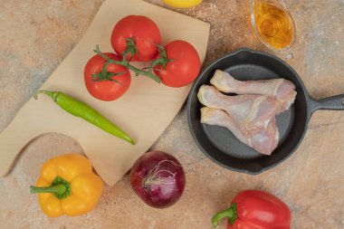 Pişmemiş tavuk bacaklı sebzeler mermer arka planda. Yüksek kalite fotoğraf