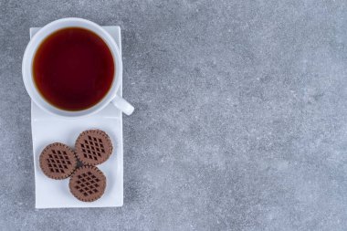 Bir fincan çay ve beyaz tabakta kakaolu bisküvi. Yüksek kalite fotoğraf