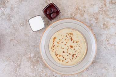 Ekşi kremalı ve çilek reçelli bir tabak krep. Yüksek kalite fotoğraf