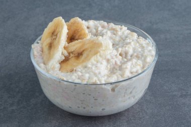 Bir tabak yulaf lapası, yanında da muz dilimleri. Yüksek kalite fotoğraf