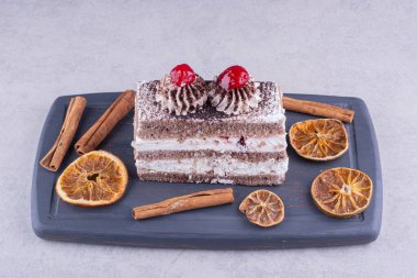 Tarçınlı lezzetli pasta ve siyah tabakta portakal dilimleri. Yüksek kalite fotoğraf