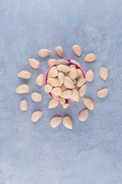 Bademler mermer arka plandaki bir kaseden dökülüyor. Yüksek kalite fotoğraf