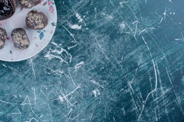 Tabakta çikolatalı kekler, mavi arka planda.