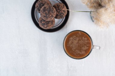 Gri arka planda çikolatalı kurabiyeli bir fincan kahve. Yüksek kalite fotoğraf