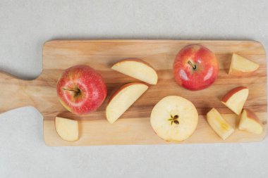 Tahtada tam ve kırmızı elma dilimleri var. Yüksek kalite fotoğraf