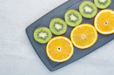 Koyu tabakta portakal ve kivi dilimleri. Yüksek kalite fotoğraf