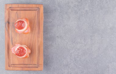 Tahtanın üzerinde, mermer zemin üzerinde dilimlenmiş bir sosis. Yüksek kalite fotoğraf