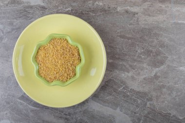 Tabakta bir kase bulgur, mermer arka planda. Yüksek kalite fotoğraf