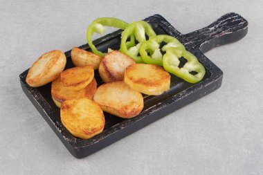 Kara tahtada kızarmış patates ve biber dilimleri. Yüksek kalite fotoğraf