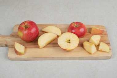 Tahtada tam ve kırmızı elma dilimleri var. Yüksek kalite fotoğraf